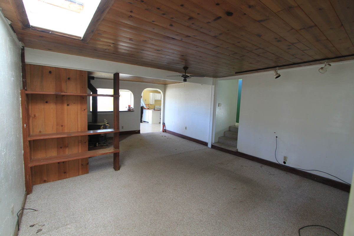 The living room is good sized.  The paint is pretty good but the carpet is stained and will need to be cleaned.  There is a nice wood stove at the far end which is your source of heat for the house.